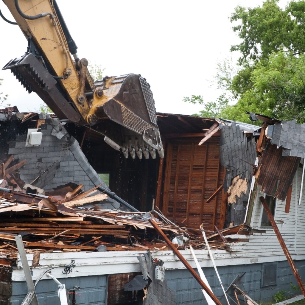 Demolition of a residential home by an excavator.