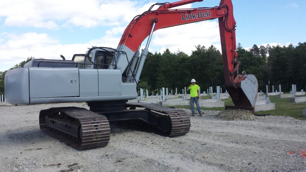 Franklin Plow Company LLC using an excavator to set the grade for a structure.